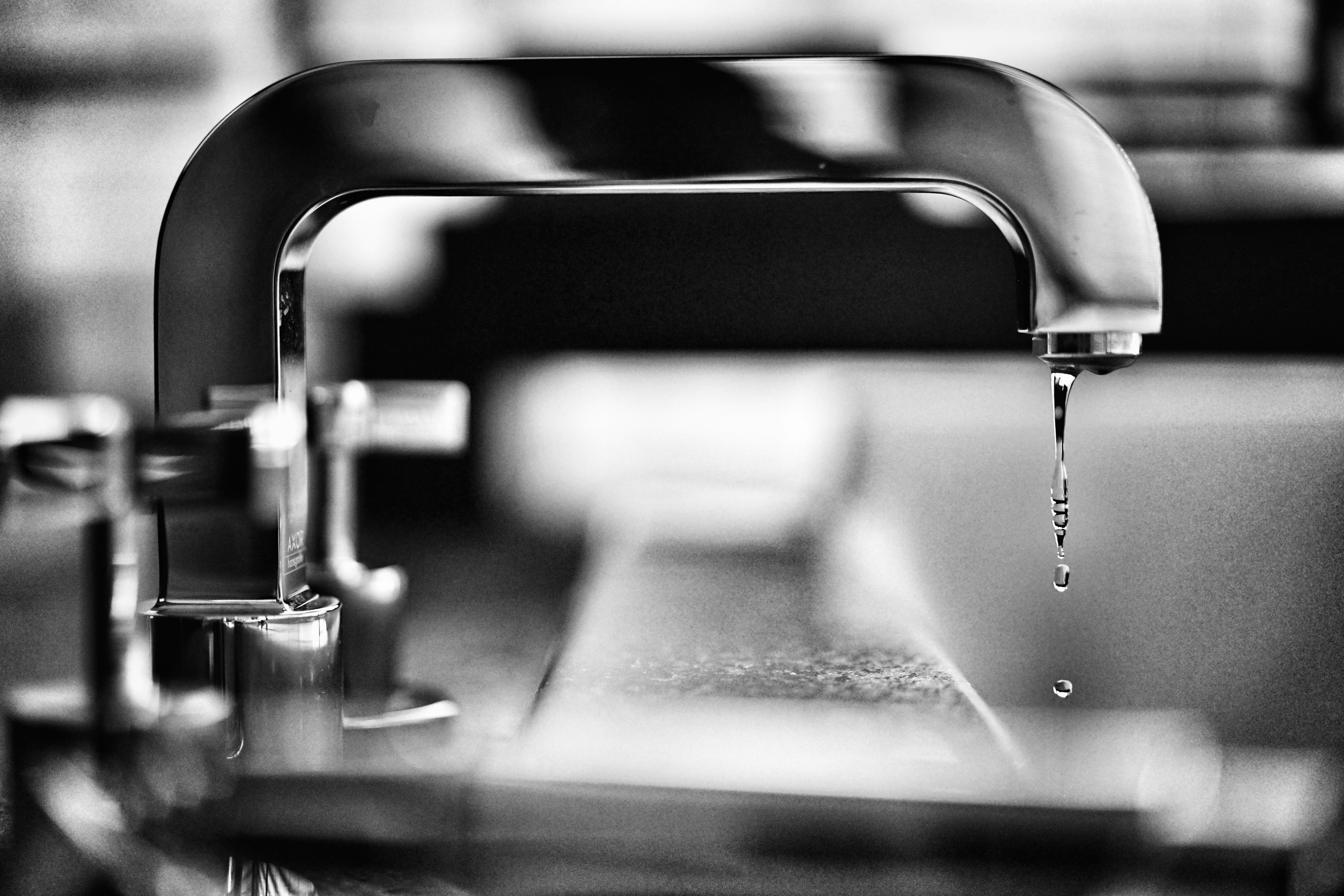 Black and white close-up of a dripping faucet