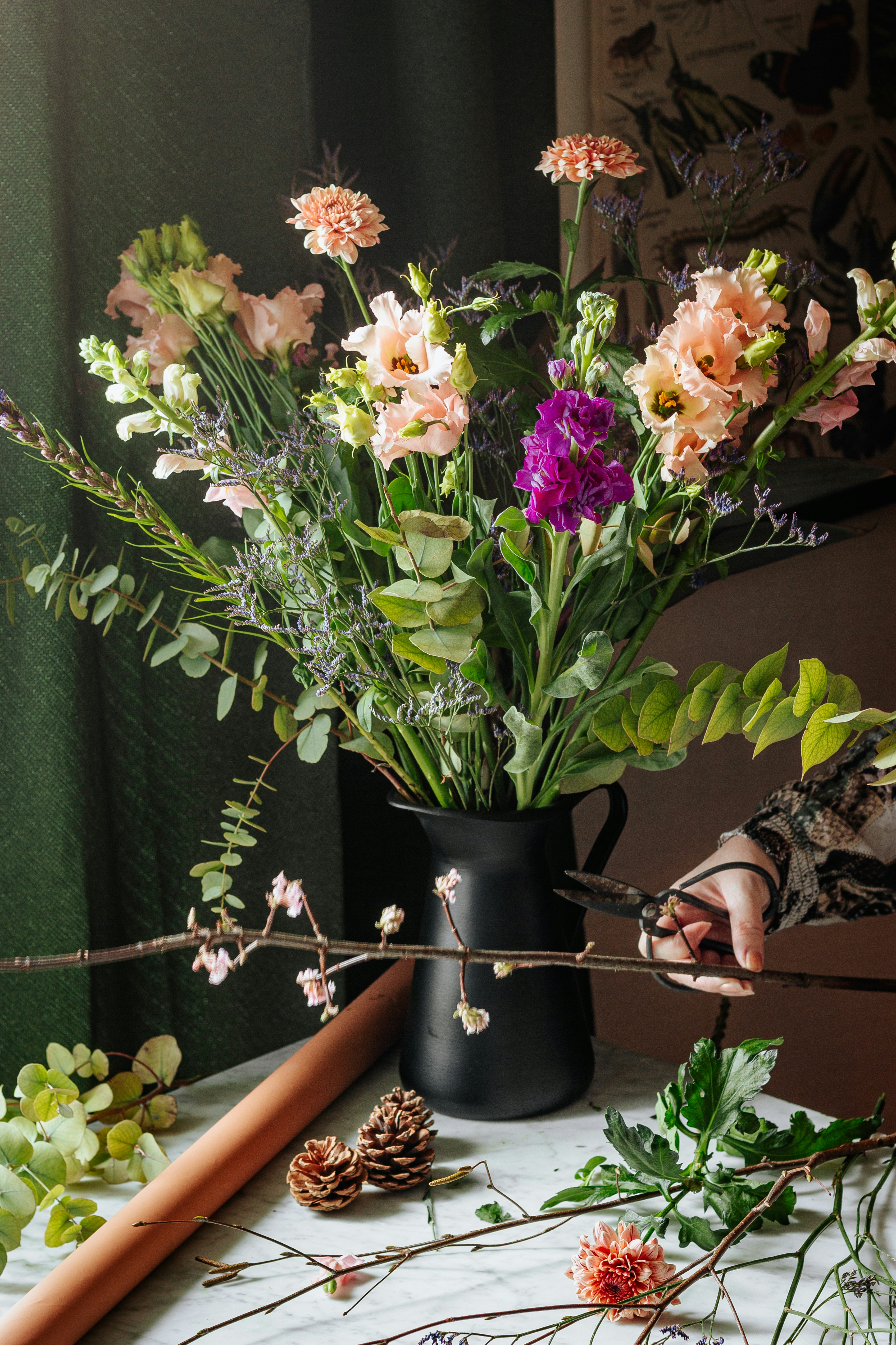Arrangement of pink lilies, roses, and hydrangea in a black vase
