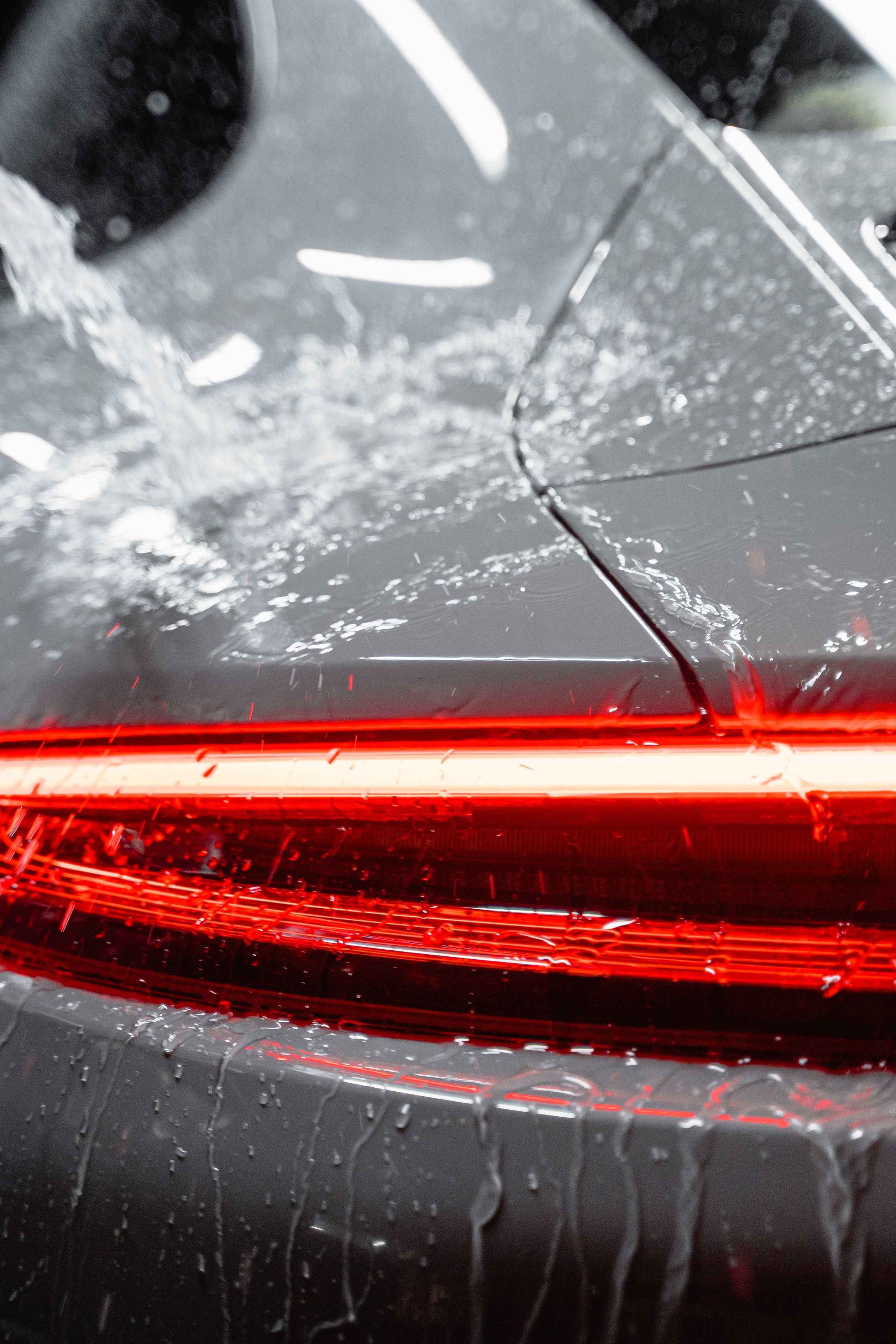 Close-up of a rinse spraying across a car's tail light